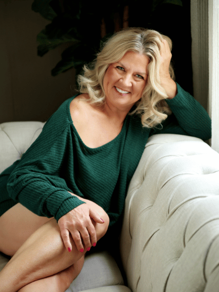 blonde woman with green sweater on couch