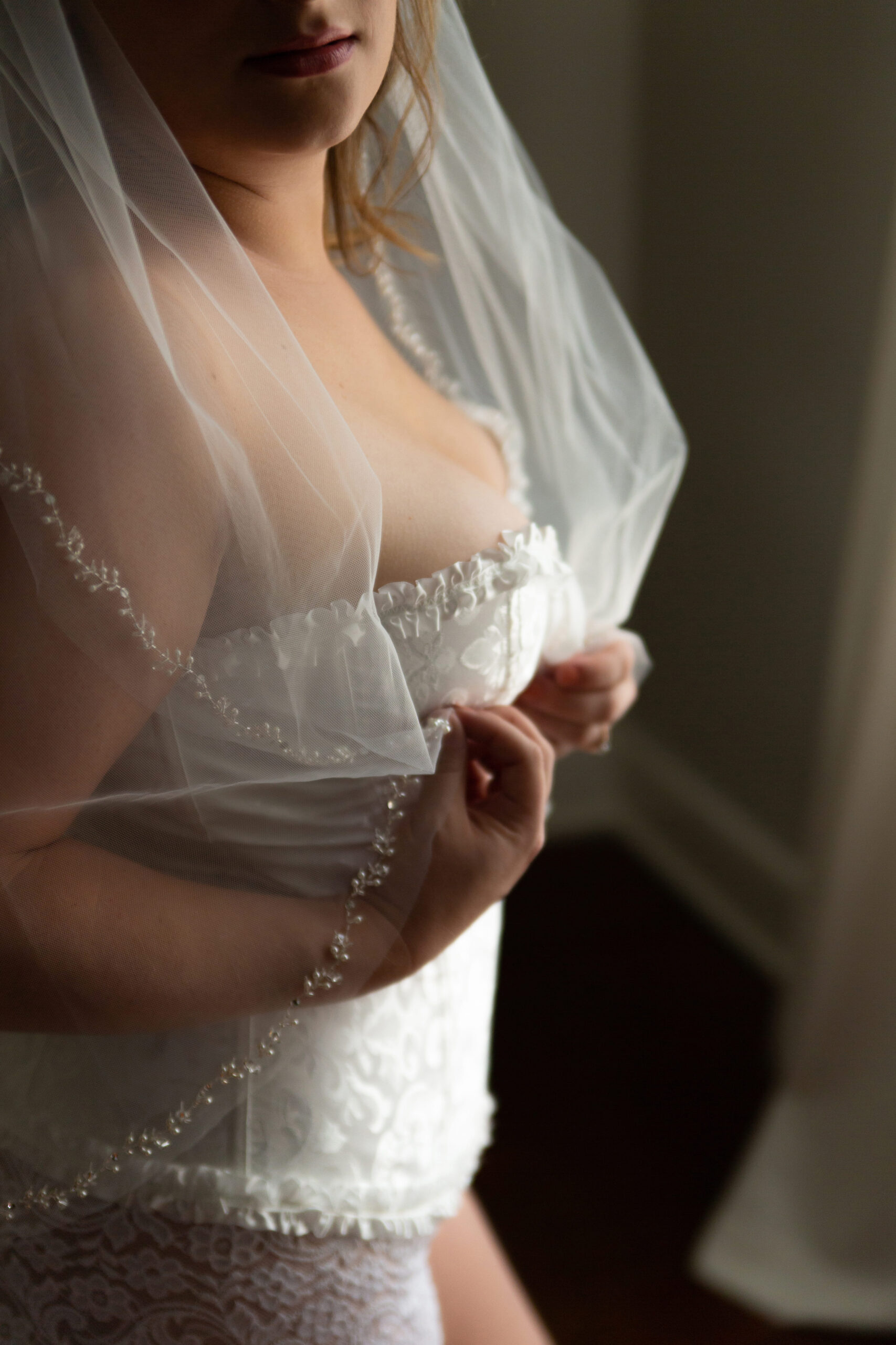woman wearing veil and bridal lingerie for a bridal boudoir photo session